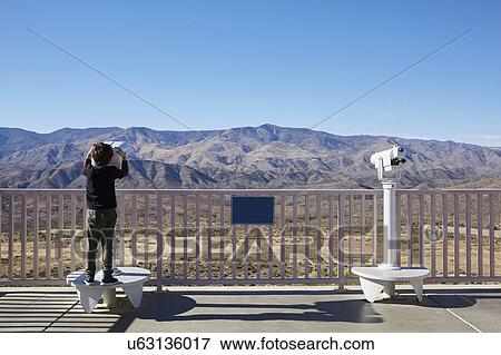 USA, Arizona, Boy (6-7) looking through coin operated binoculars View Large Photo Image Stock Photo - USA, Arizona, Boy (6-7) looking through coin operated binoculars. Fotosearch