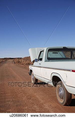 Stock Image - USA, Arizona, Broken pick up truck parked on desert road. Fotosearch