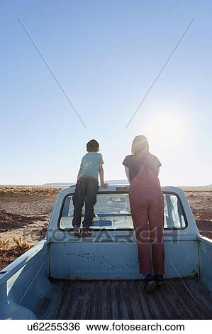 Stock Photograph - USA, Arizona, Mother with boy (6-7) looking at view from pick-up truck. Fotosearch