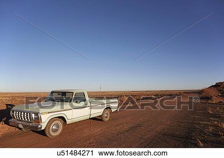 Stock Image - USA, Arizona, Pick-up truck on desert road. Fotosearch