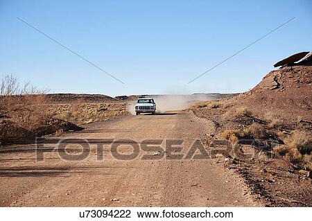 Stock Image - USA, Arizona, Pick up truck on dusty road. Fotosearch