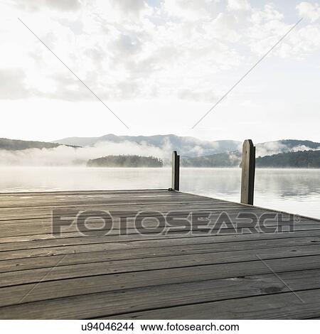 Picture - USA, New York, Lake Placid, Pier with foggy lake in background. Fotosearch
