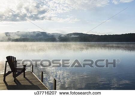 Stock Photo - USA, New York State, Adirondack chair on jetty by Lake Placid. Fotosearch