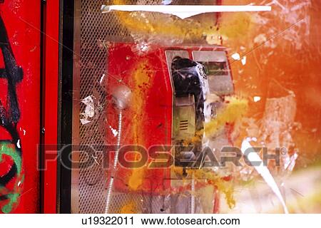 Stock Image - Vandalized public phone booth on street.. Fotosearch