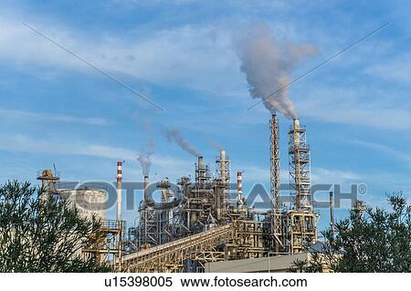Stock Photography - Vapour smoke billowing from industrial building, Cagliari, Sardinia, Italy. Fotosearch