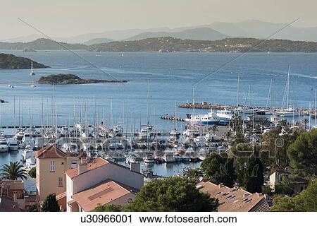 Stock Image - View of rooftops and marina, Porquerolles, Provence-Alpes-Cote d'Azur. Fotosearch