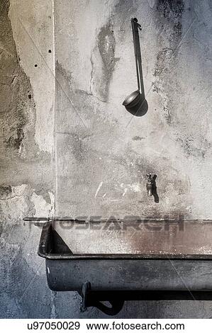 Stock Photo - Wall trough and tap with ladle. Fotosearch