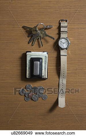 Stock Photo - Watch, keys and money on table. Fotosearch