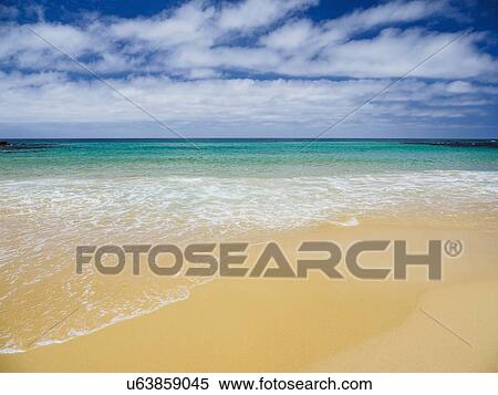Stock Photography - White clouds above sea and sandy beach. Fotosearch