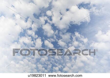 Stock Image - White cumulus clouds on blue sky. Fotosearch