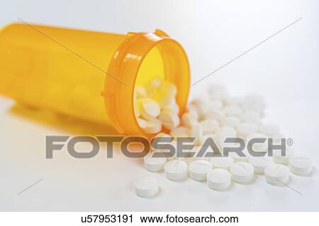 Stock Image - White pills spilling from bottle.. Fotosearch