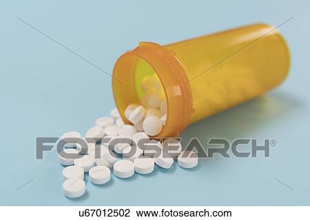 Stock Image - White pills spilling from bottle.. Fotosearch