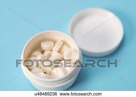 Stock Photograph - White tablets in a plastic container.. Fotosearch
