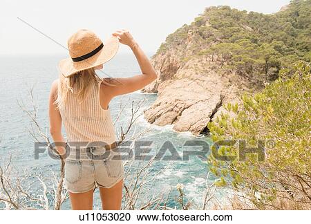 Woman along coastline, looking at view, rear view, Tossa de mar, Catalonia, Spain View Large Photo Image Stock Image - Woman along coastline, looking at view, rear view, Tossa de mar, Catalonia, Spain. Fotosearch
