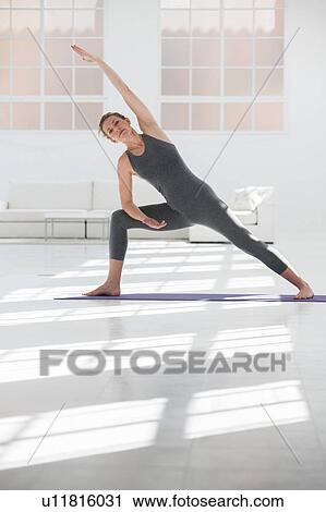 Woman at home, doing yoga, in yoga position View Large Photo Image Stock Image - Woman at home, doing yoga, in yoga position. Fotosearch