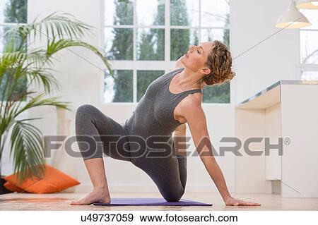Woman at home, doing yoga, in yoga position View Large Photo Image Stock Photo - Woman at home, doing yoga, in yoga position. Fotosearch