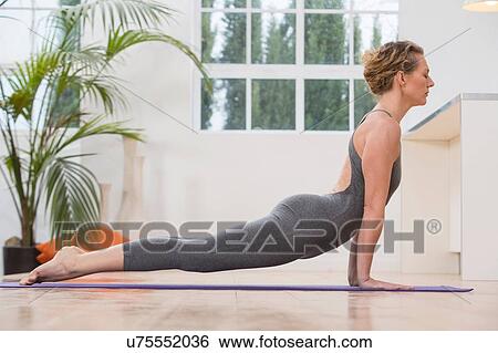 Woman at home, doing yoga, in yoga position View Large Photo Image Stock Photograph - Woman at home, doing yoga, in yoga position. Fotosearch