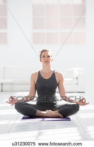 Stock Photography - Woman at home, doing yoga, in yoga position. Fotosearch