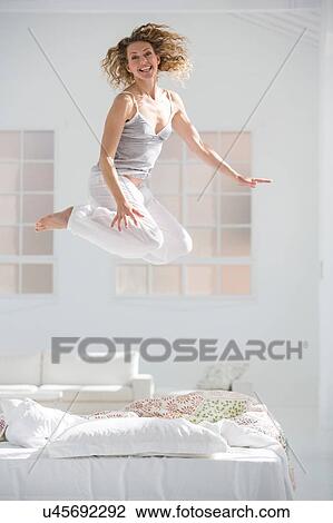 Woman at home, jumping for joy View Large Photo Image Stock Image - Woman at home, jumping for joy. Fotosearch