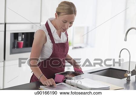 Woman checking recipe View Large Photo Image Stock Image - Woman checking recipe. Fotosearch