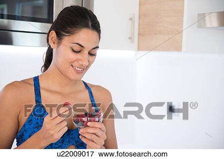 Stock Photo - Woman eating fruit. Fotosearch