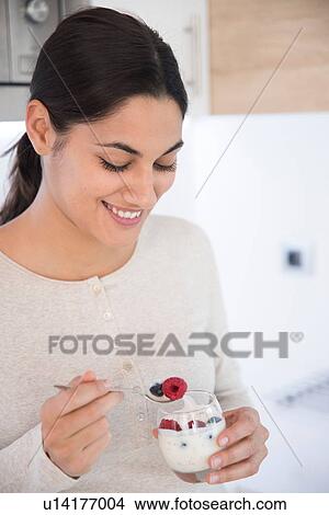 Picture - Woman eating fruits and yoghurt. Fotosearch