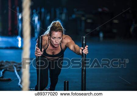 Woman exercising in gymnasium, sled training View Large Photo Image Stock Image - Woman exercising in gymnasium, sled training. Fotosearch
