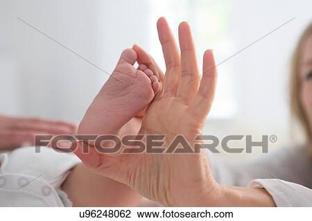 Woman holding baby son's bare foot, close up View Large Photo Image Stock Image - Woman holding baby son's bare foot, close up. Fotosearch