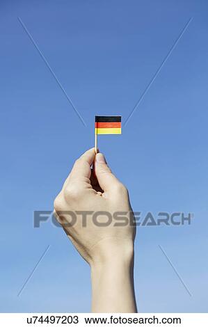 Woman holding German flag in hand View Large Photo Image Stock Image - Woman holding German flag in hand. Fotosearch