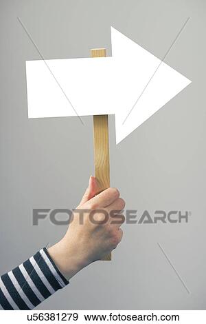 Stock Photo - Woman holding guiding arrow sign.. Fotosearch