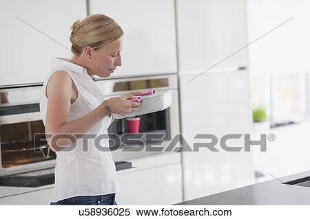 Stock Photography - Woman holding hot casserole dish. Fotosearch