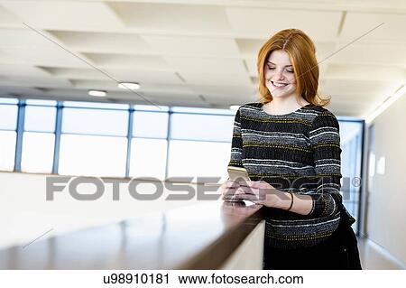 Woman leaning on low wall and texting View Large Photo Image Stock Image - Woman leaning on low wall and texting. Fotosearch