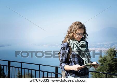 Stock Image - Woman looking at folding map, San Zeno di Montagna, Veneto, Italy, Europe. Fotosearch