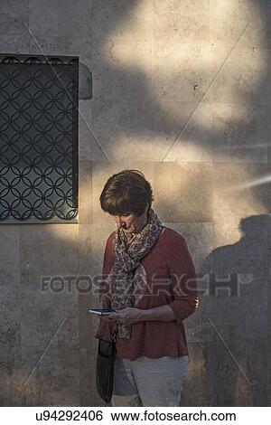 Woman looking at smartphone in street View Large Photo Image Stock Photograph - Woman looking at smartphone in street. Fotosearch