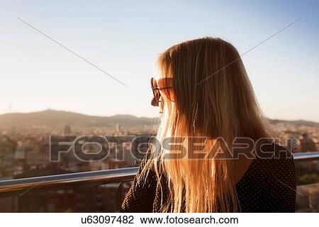 Stock Image - Woman looking at view of city, Barcelona, Catalonia, Spain. Fotosearch