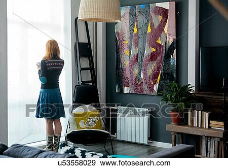 Woman looking out window at home View Large Photo Image Stock Photo - Woman looking out window at home. Fotosearch
