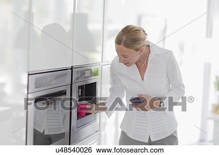 Woman making coffee in kitchen View Large Photo Image Stock Photograph - Woman making coffee in kitchen. Fotosearch
