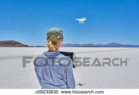 Woman on salt flats, flying drone, rear view, Salar de Uyuni, Uyuni, Oruro, Bolivia, South America View Large Photo Image Stock Photography - Woman on salt flats, flying drone, rear view, Salar de Uyuni, Uyuni, Oruro, Bolivia, South America. Fotosearch