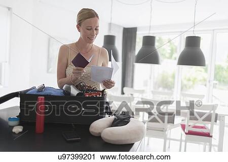 Stock Image - Woman packing luggage. Fotosearch