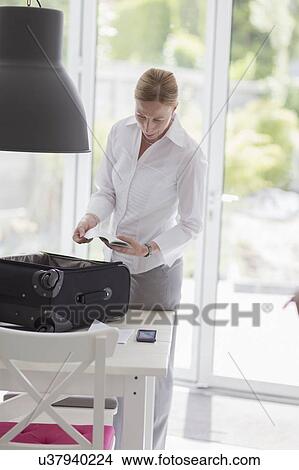 Woman packing suitcase for business travel View Large Photo Image Picture - Woman packing suitcase for business travel. Fotosearch