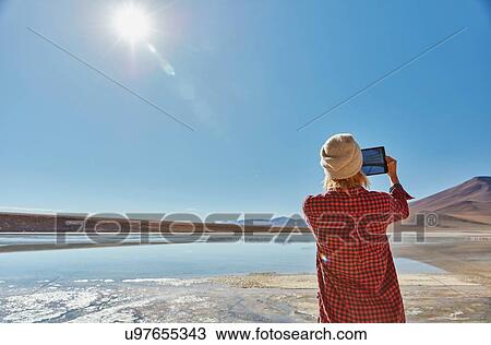 Woman photographing landscape, using digital tablet, Salar de Chalviri, Chalviri, Oruro, Bolivia, South America View Large Photo Image Stock Image - Woman photographing landscape, using digital tablet, Salar de Chalviri, Chalviri, Oruro, Bolivia, South America. Fotosearch