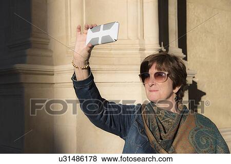 Stock Photo - Woman taking photo with smartphone. Fotosearch