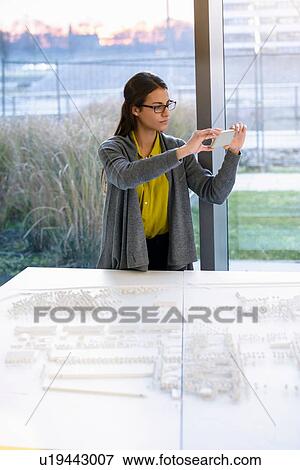Woman taking photograph of town model View Large Photo Image Stock Photo - Woman taking photograph of town model. Fotosearch