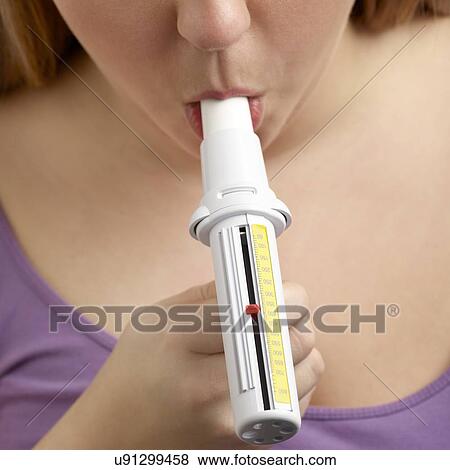 Woman using a peak flow metre. View Large Photo Image Stock Photo - Woman using a peak flow metre.. Fotosearch