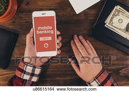 Picture - Woman using mobile banking app on smart phone.. Fotosearch