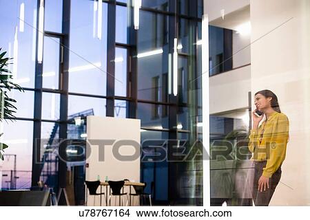 Woman using mobile phone in office View Large Photo Image Picture - Woman using mobile phone in office. Fotosearch