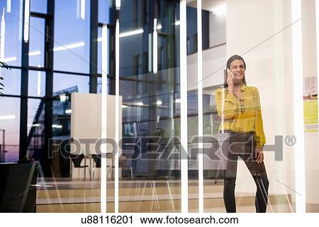 Woman using mobile phone in office View Large Photo Image Stock Image - Woman using mobile phone in office. Fotosearch