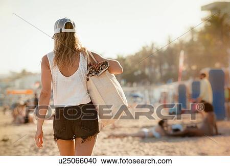 Woman walking along beach, rear view, Sitges, Catalonia, Spain View Large Photo Image Stock Image - Woman walking along beach, rear view, Sitges, Catalonia, Spain. Fotosearch