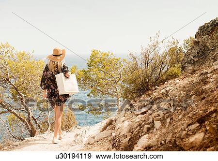 Woman walking along coastal pathway, rear view, Tossa de mar, Catalonia, Spain View Large Photo Image Stock Photo - Woman walking along coastal pathway, rear view, Tossa de mar, Catalonia, Spain. Fotosearch