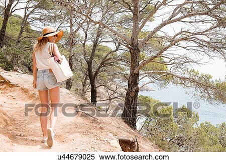 Woman walking along coastal pathway, Tossa de mar, Catalonia, Spain View Large Photo Image Stock Photography - Woman walking along coastal pathway, Tossa de mar, Catalonia, Spain. Fotosearch